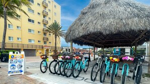 A beachfront hotel with a thatched-roof structure, bicycles with baskets, and a rental sign. - Paradise Oceanfront HBH (Hollywood)