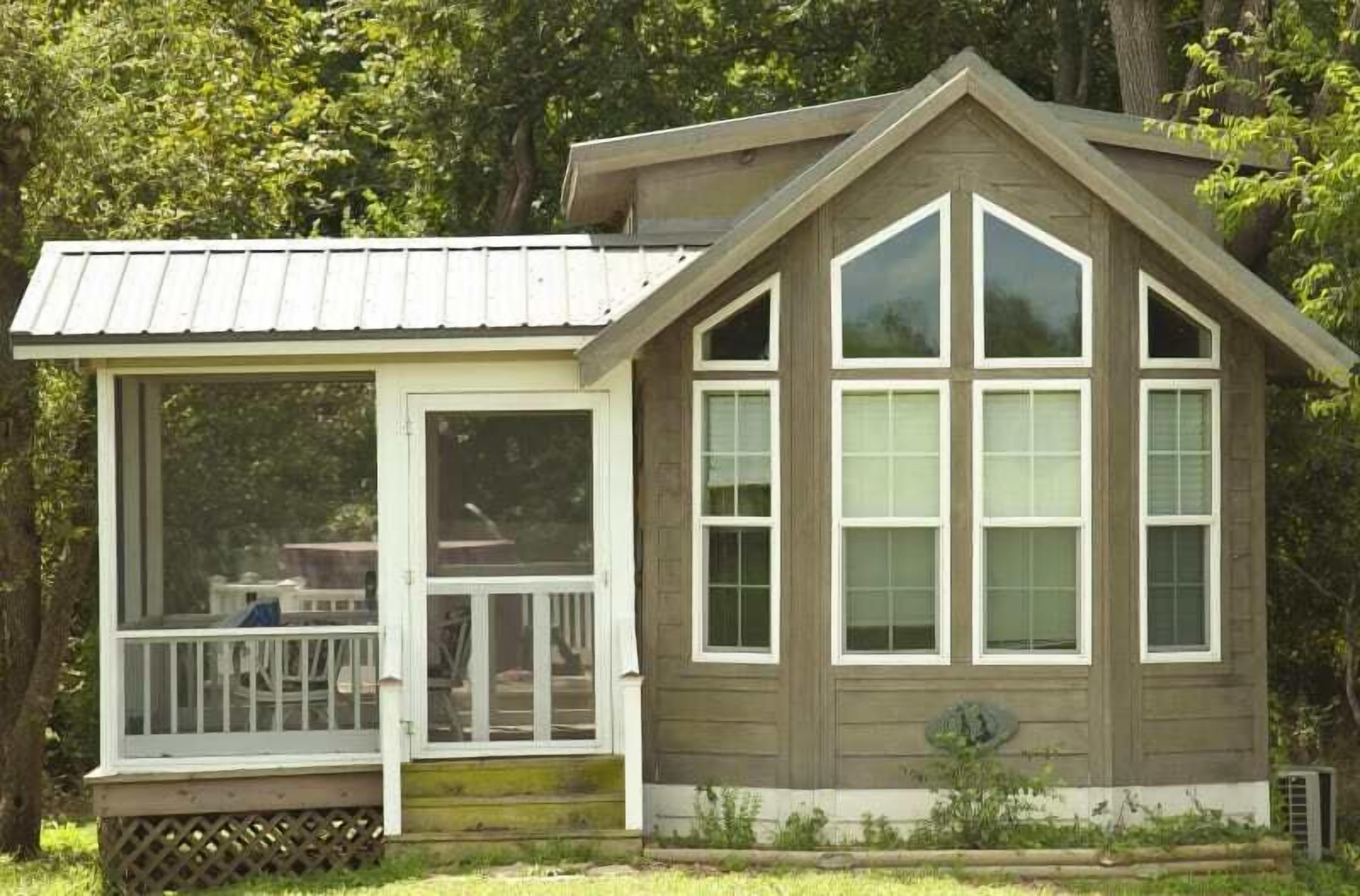 A wooden cabin with a covered porch and large windows.