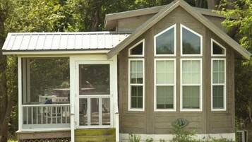 A wooden cabin with a covered porch and large windows.