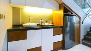 Une cuisine moderne avec un évier blanc, des appareils électroménagers en acier inoxydable et des meubles de cuisine en bois.