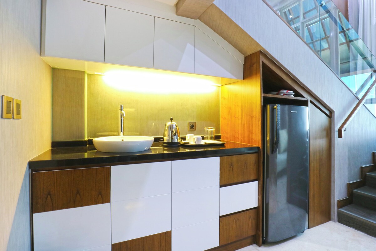 A modern kitchen with a white sink, stainless steel appliances, and a wooden countertop.