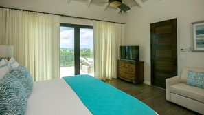 A bedroom with a large bed, a dresser, a television, and a view of the outdoors. - Marathon:  Full AC! Pool! Amazing Views! (St. John)
