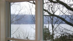 Une fenêtre donnant sur un lac et des arbres.