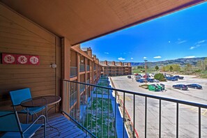 Un balcon donnant sur un parking et sur des bâtiments en arrière-plan.
