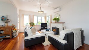 A modern living room with a fireplace, comfortable seating, and a television.