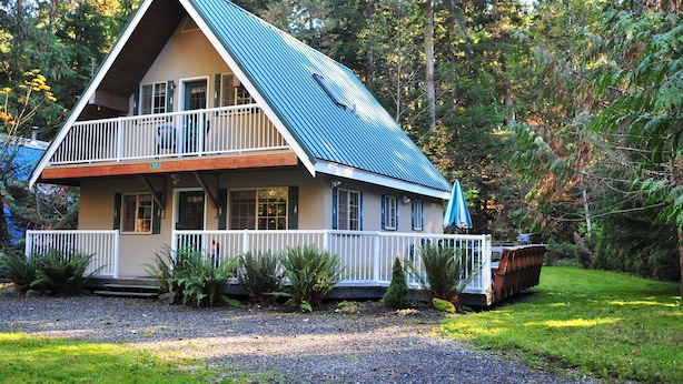 A two-story house with a balcony, surrounded by a forest. - 2-Story Chalet, clean, 3Br / 2Ba in Snowline, best rates, WiFi and Hot Tub (Glacier)