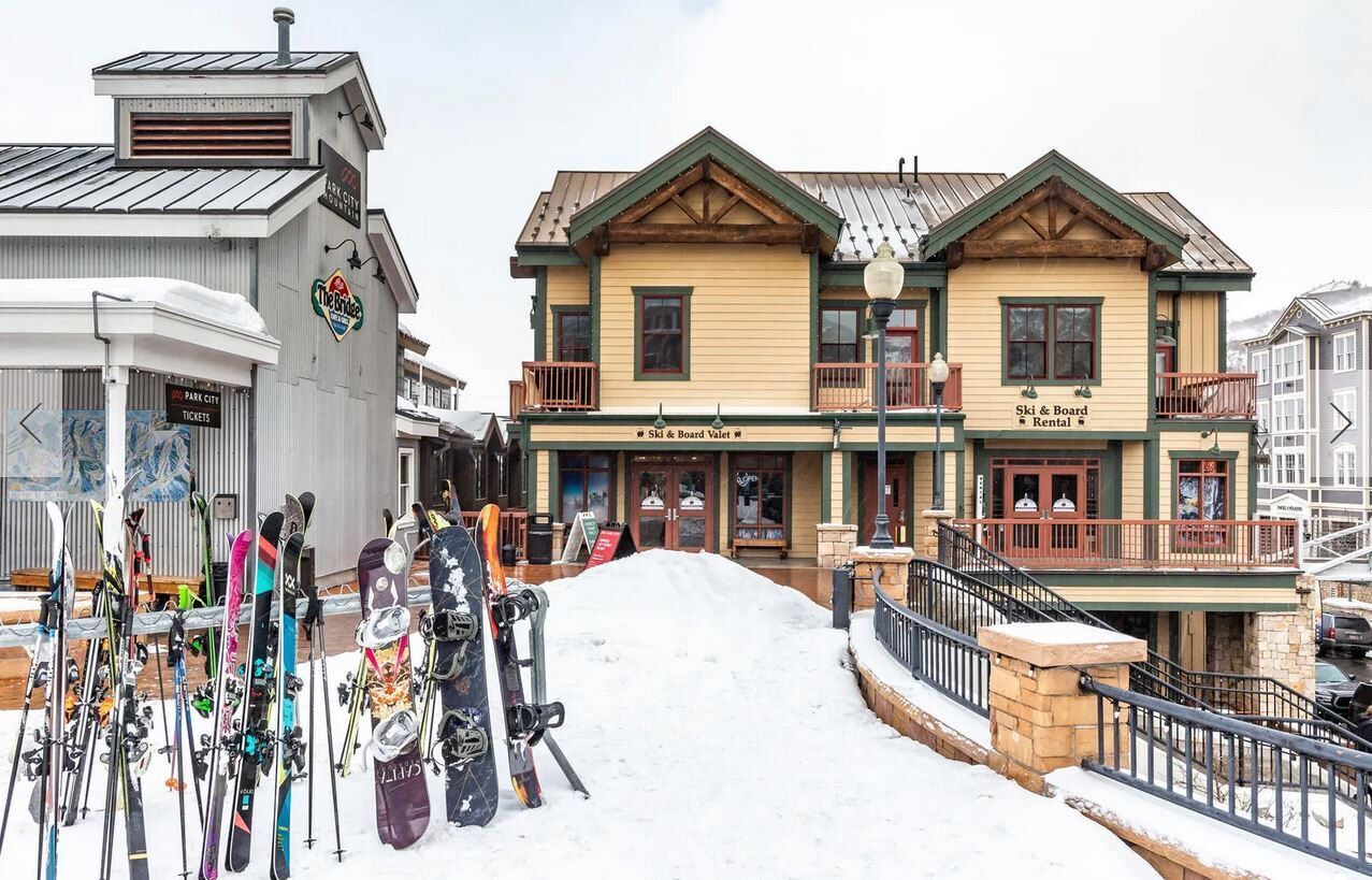 A ski rental building with a sign for "Ski & Board Rental" and a "Park City Tickets" booth.
