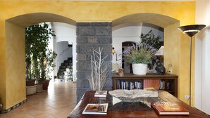 A spacious hallway with a wooden table, books, and decorative items. - AMORE RENTALS - Villa Il Pino with Private Pool, Garden, BBQ, Parking (Sant´Agata sui Due Golfi)