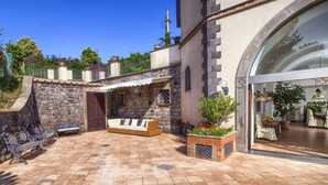 A courtyard with stone walls, a bench, and potted plants. - AMORE RENTALS - Villa Il Pino with Private Pool, Garden, BBQ, Parking (Sant´Agata sui Due Golfi)