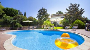 A swimming pool with lounge chairs and an inflatable ring. - AMORE RENTALS - Villa Il Pino with Private Pool, Garden, BBQ, Parking (Sant´Agata sui Due Golfi)