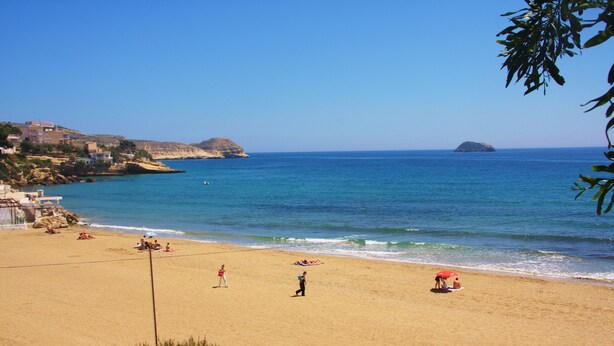 A beach with clear blue water, a few people, and a small island in the distance. - House with terrace of flowers and solarium, near beaches, A/C, wifi, Sat TV, BBQ (San Juan de los Terreros)