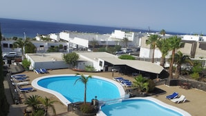 A resort with a large swimming pool, lounge chairs, and a view of the ocean. - Quiet apartment near the beach VV-35-3-0002306 (Tías)