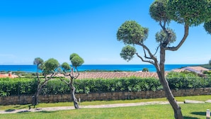 A coastal landscape with a stone wall, a pathway, and neatly trimmed trees. - Fantastic holiday apartment with sea view - Villa Nina (San Teodoro)