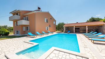 Relax by the pool surrounded by lounge chairs in a clean and elegant space.