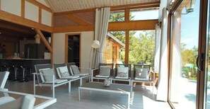 A modern interior with a dining area, seating, and large windows. - La Grange de mon père - Collection Idylliq (Jouy-Le-Potier)