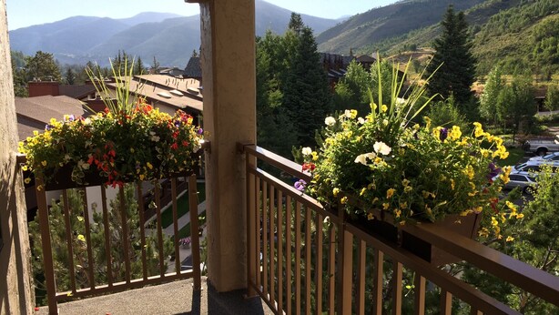 A balcony with a view of mountains and a parking area. - Walk to Vail Village Restaurants,  Shops & Lifts - Epic Views, Top Rated Condo! (Vail)