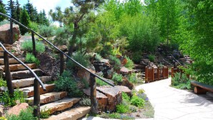 A stone staircase leading up a rocky path surrounded by greenery and a wooden bench. - Walk to Vail Village Restaurants,  Shops & Lifts - Epic Views, Top Rated Condo! (Vail)