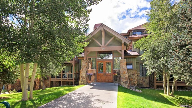 A lodge with a stone facade, a wooden entrance, and a covered porch. - Free SkyCard Act-Fitness Center, Gas Fireplace - Highland Greens Lodge 305 (Breckenridge)