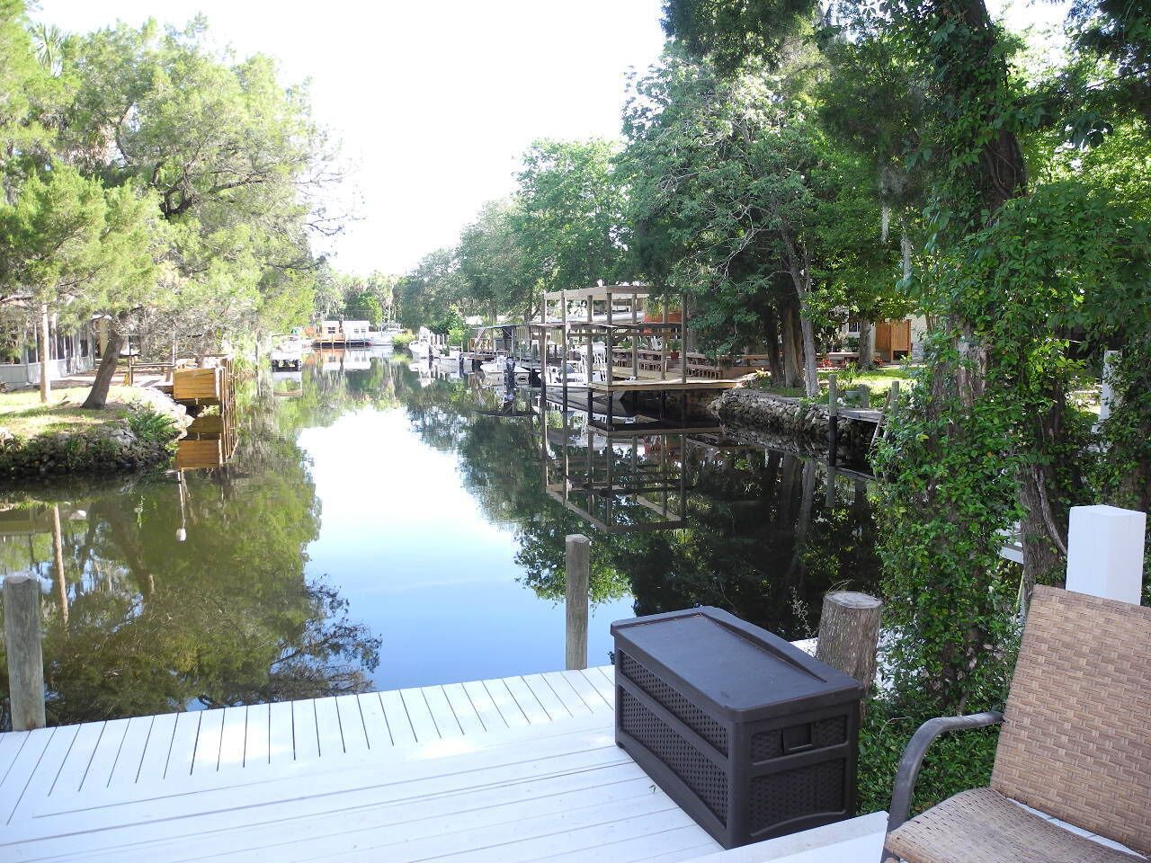 A docked boat on a calm waterway with wooden walkways and greenery.