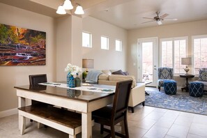 Relax in this inviting living area with a dining table for four, sofa, and armchairs.