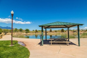 Situated near a body of water, this serene pavilion offers a tranquil retreat with a bench and beautiful views of the surrounding mountains.