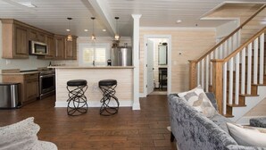 A modern kitchen with wooden cabinets, stainless steel appliances, and a central island with bar stools.
