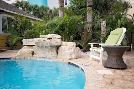 Una piscina al aire libre, sillones reclinables de piscina