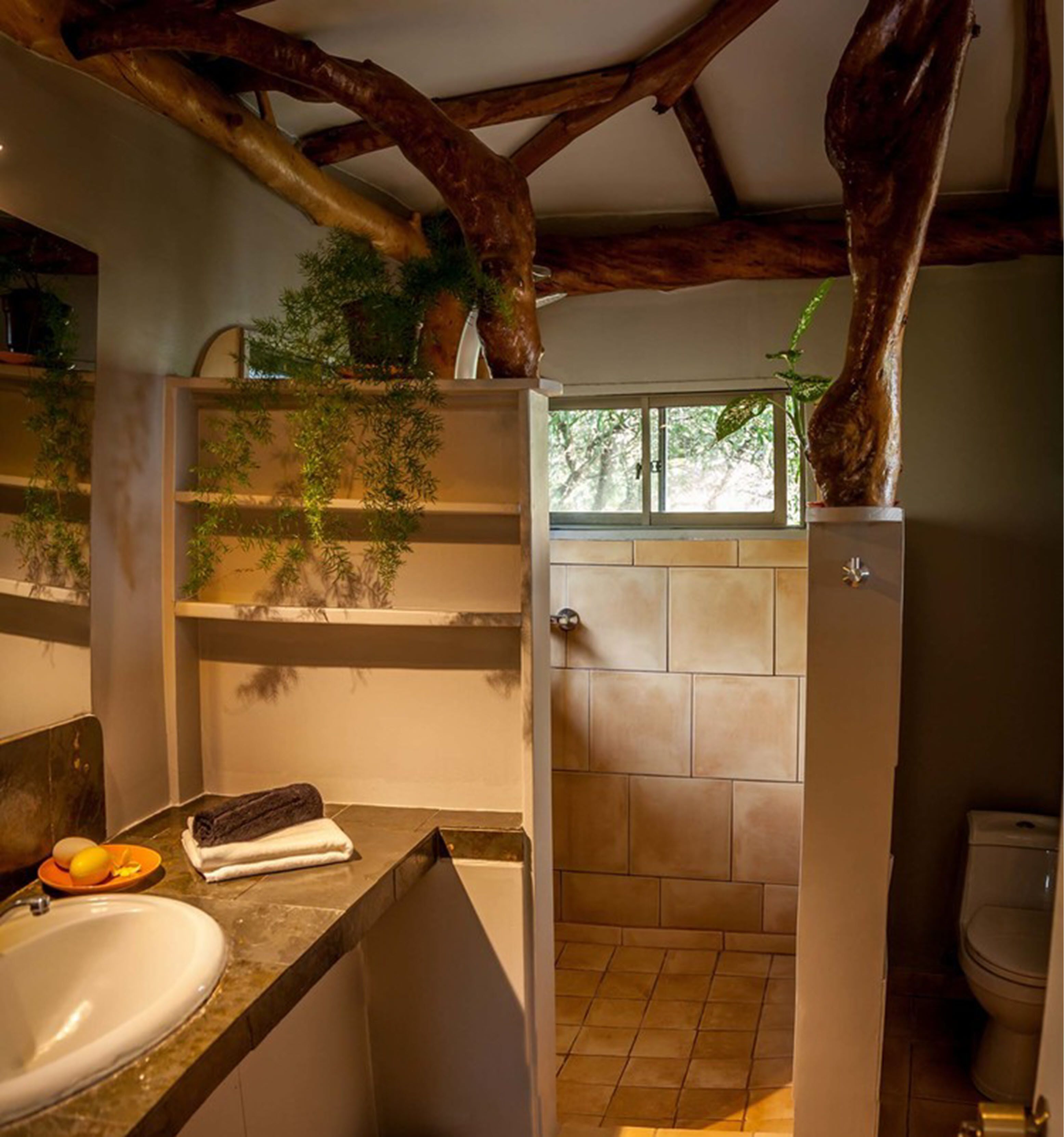 A bathroom with a sink, towel, and a shower area.