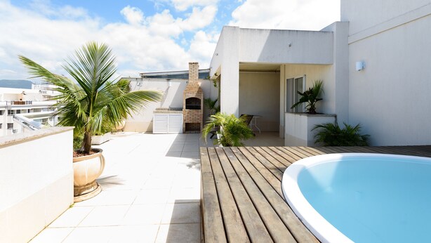 A rooftop patio with a swimming pool, a brick fireplace, and potted plants. - Omar do Rio - Apartamento CobR (Rio de Janeiro)