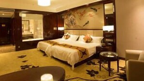 A hotel room with a large bed, a desk, a chair, and a nightstand. - Bo Jue Hotel (Shanghai)