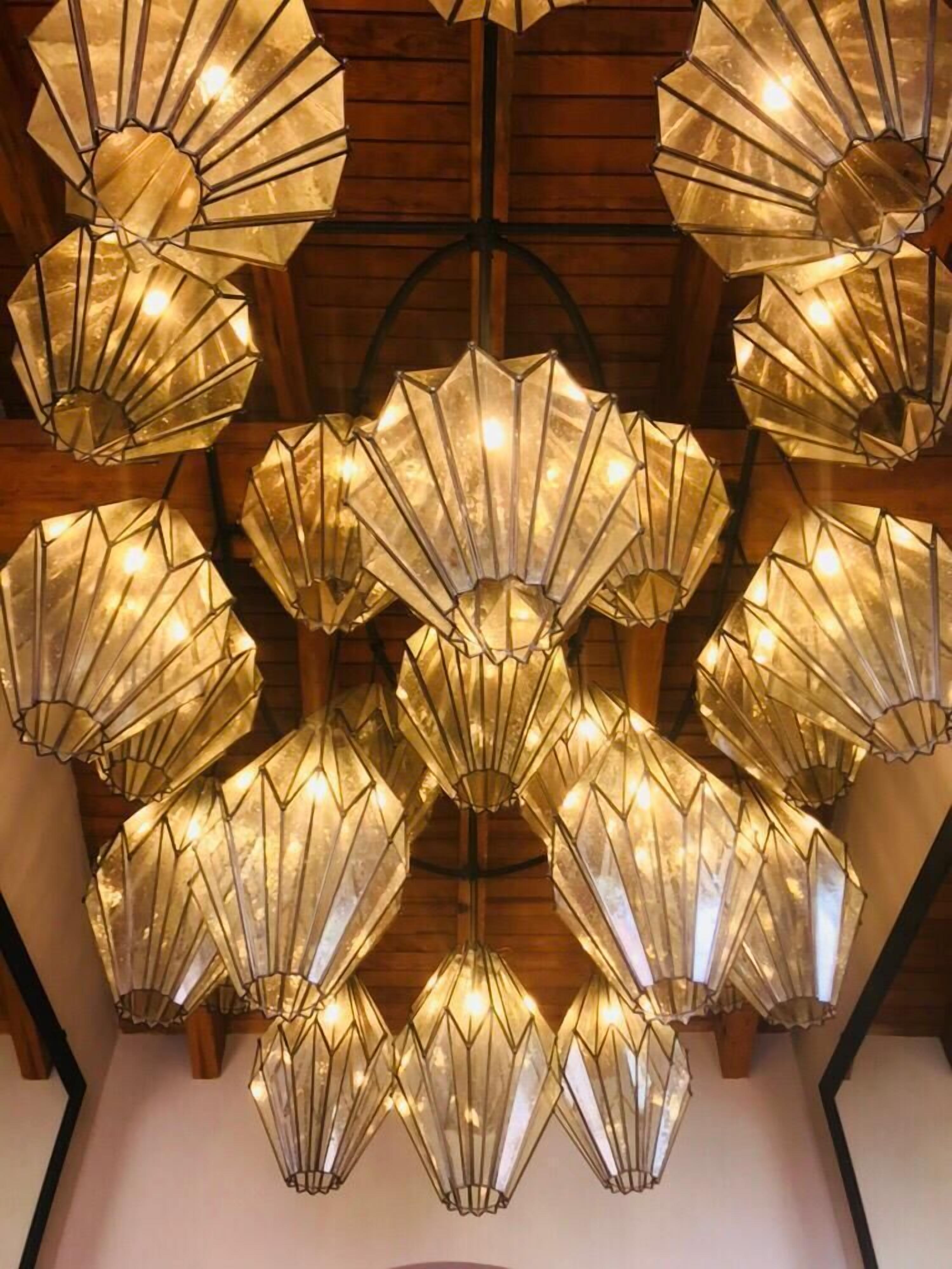 Teto com várias luminárias geométricas.