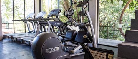 A gym with treadmills, an elliptical, and a stationary bike.