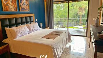 Habitación de hotel con una cama grande, vistas al exterior y una obra de arte en la pared.