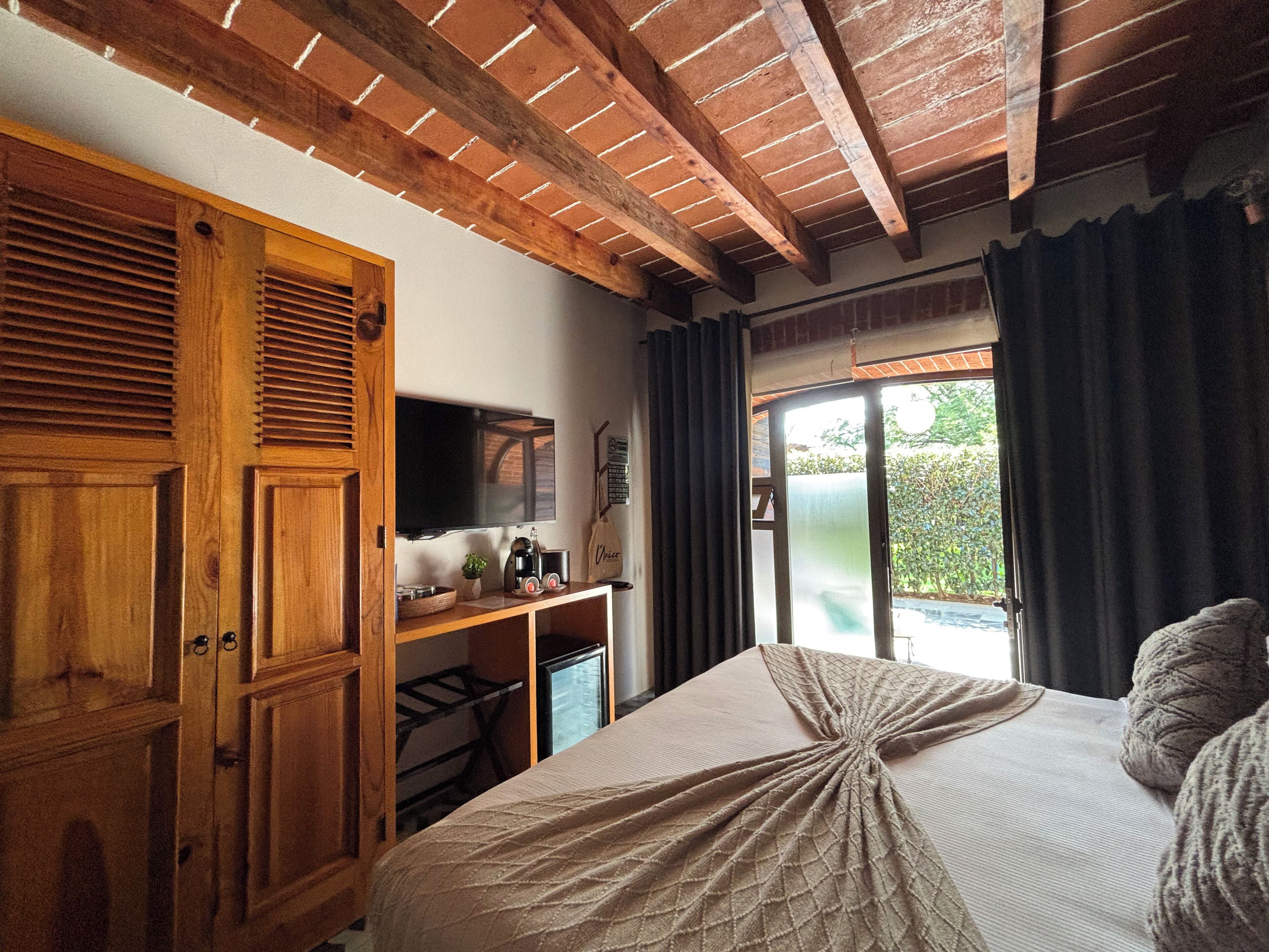 Un dormitorio con cama, armario de madera y televisor sobre un mueble.