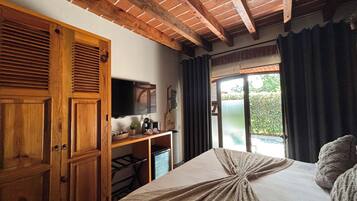 Un dormitorio con cama, armario de madera y televisor sobre un mueble.