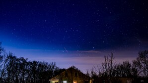 Ein Haus mit Veranda und Sternenhimmel.