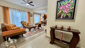 Uma sala de estar com sofá, mesa de centro e um quadro na parede.