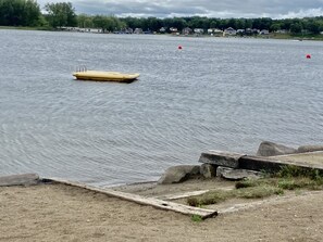 A lake with a small yellow boat and red buoys. There are houses in the background. - 5 Bedroom Lake Access House and Entertainment Bldg  (Fremont)