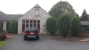 Un edificio de piedra con techo triangular y puerta de garaje.