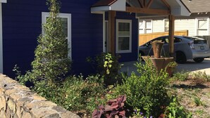 Una casa azul con un muro de piedra y un jardín.