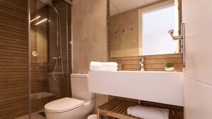 Une salle de bain moderne avec une douche à parois de verre, des toilettes blanches, un meuble-lavabo en bois avec un miroir et une petite étagère sur laquelle est posée une serviette.