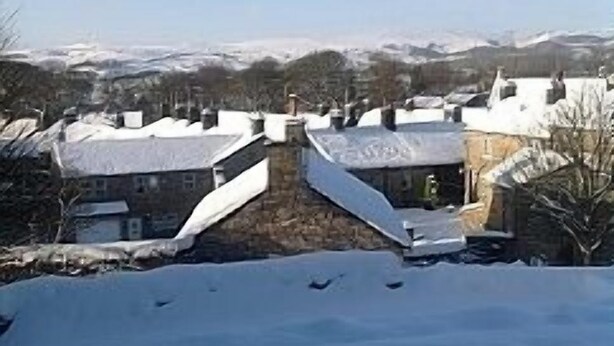 A snow-covered village with traditional stone houses, a prominent stone wall, and a clear blue sky. - Cottage in Grassington in the heart of the Yorkshire dales. Free parking permit. (Grassington)