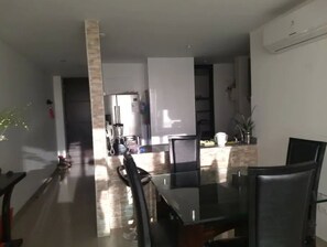 Enjoy meals in a stylish dining area with a glass-top table and comfortable chairs.