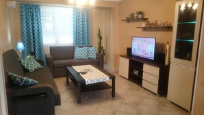 Un soggiorno con divano, tavolino, televisore e oggetti decorativi.