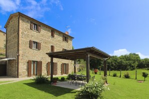 A stone building with a covered patio and outdoor seating area.