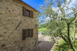 Un bâtiment en pierre avec deux fenêtres et un balcon.