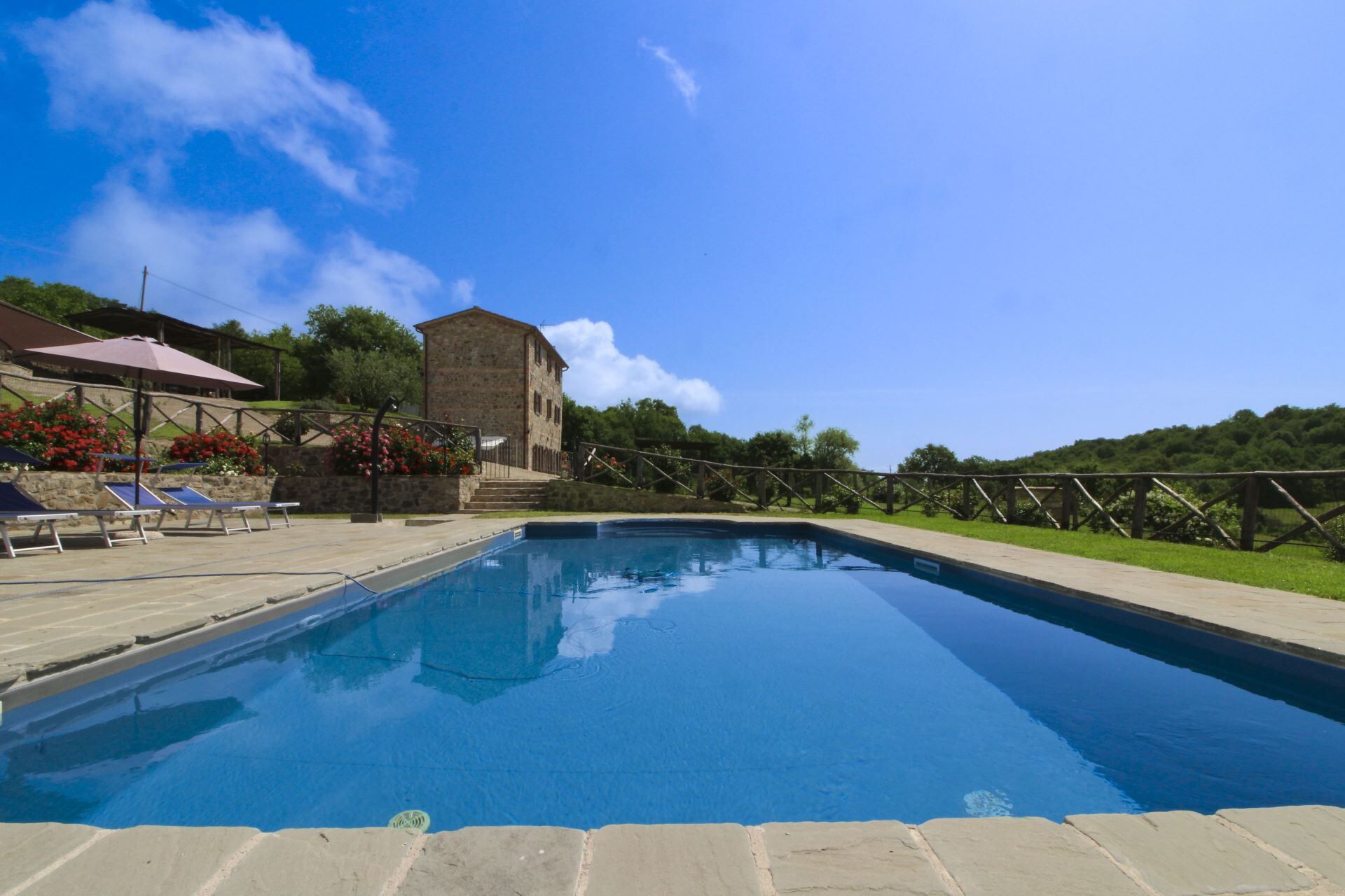 A swimming pool with a stone building in the background.