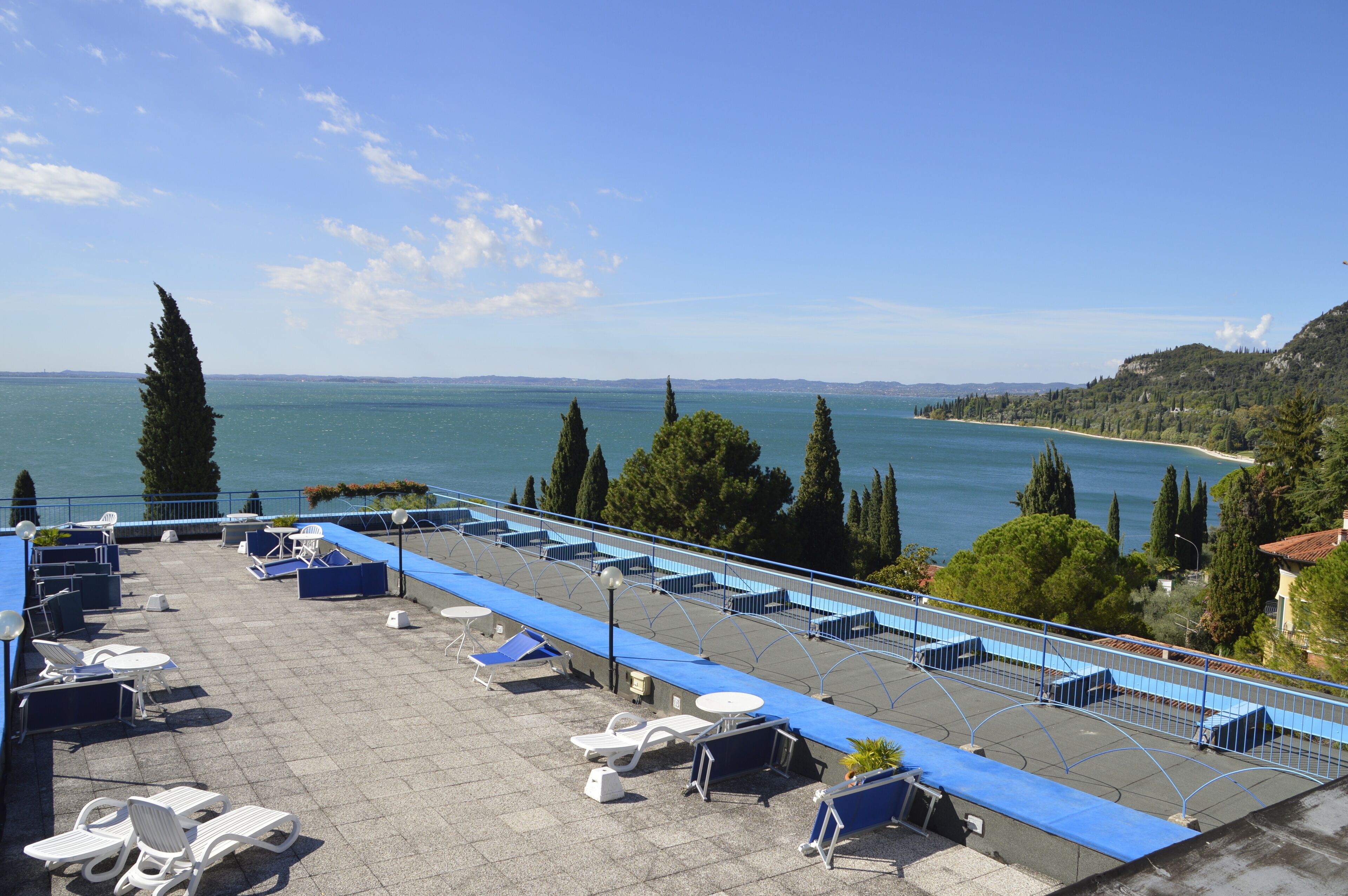 A rooftop terrace with sun loungers and a view of the sea.