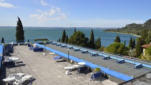Terraza en la azotea con sillones de sol y vista al mar.