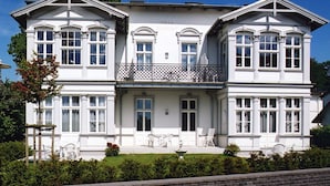 Ein großes, zweistöckiges Gebäude mit Balkon und zahlreichen Fenstern.